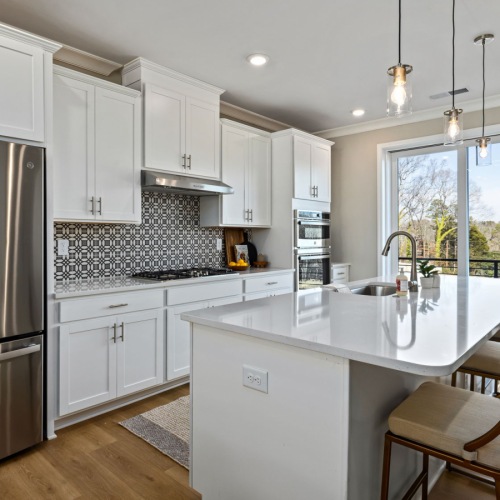 Kitchen oversized island and quartz countertops in kitchen with windows
